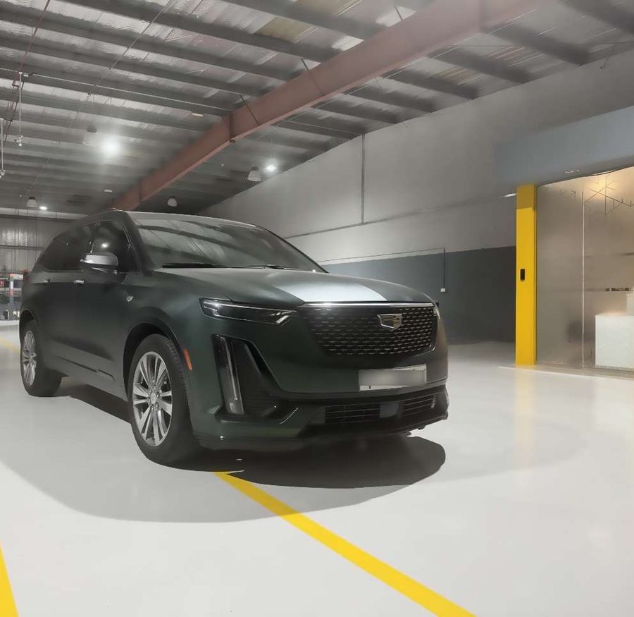 A dark green Cadillac XT6 at the BavarLand workshop entrance